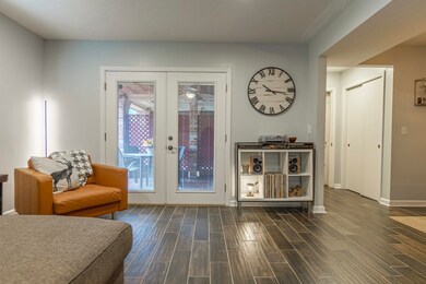 Doorway with dark wood-type flooring and french do