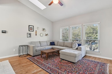 Living room with a skylight, baseboards, ceiling f