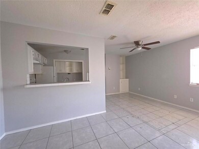 Unfurnished room featuring a textured ceiling, light tile patterned floors, ceiling fan, baseboards, and visible vents