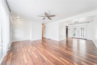 Unfurnished living room featuring ceiling fan, hardwood / wood-style flooring, and french doors