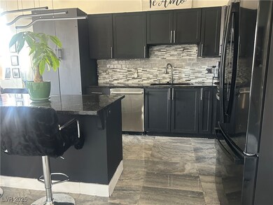 Kitchen with freestanding refrigerator, dark stone