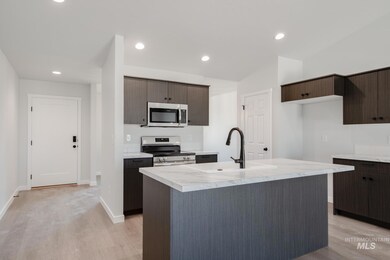 Kitchen with appliances with stainless steel finishes, light countertops, light wood finished floors, dark brown cabinets, and recessed lighting
