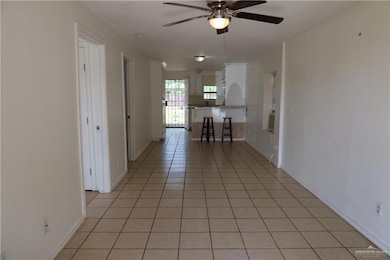 Corridor featuring light tile patterned floors and baseboards