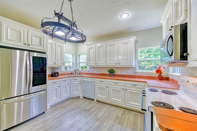 Love this Kitchen with new refrigerator and microwave. Cabinets newly painted and new lighting and flooring here too!  Beautiful views of the back yard and lots of natural light with the corner windows.
