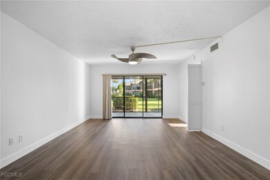 Empty room with dark wood finished floors and a ceiling fan