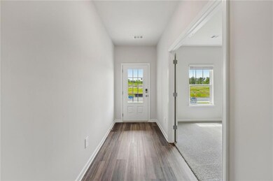 Doorway with dark wood-type flooring and baseboard