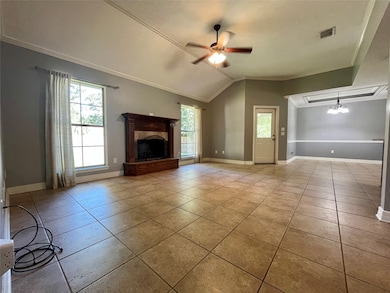 Unfurnished living room with a ceiling fan, crown molding, light tile patterned floors, a premium fireplace, and a chandelier