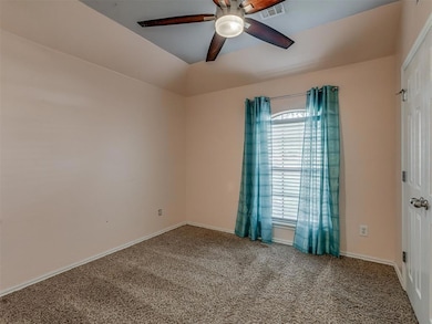 Spare room featuring a ceiling fan, carpet, and baseboards