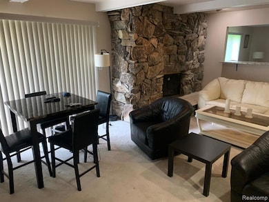 Living area with a fireplace, beam ceiling, and carpet floors