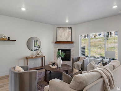 Living area featuring a brick fireplace, wood finished floors, and recessed lighting