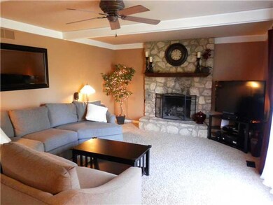 Great Room. Gorgeous Focal Wall with Stone Wood Burning Fireplace! Crown Moulding and Beamed Ceiling with Ceiling Fan! Newer Carper (2013)!