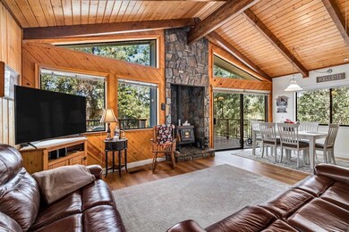 Living room featuring wooden ceiling, beam ceiling, hardwood / wood-style flooring, and a wood stove