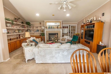 Living room with recessed lighting, light colored carpet, a ceiling fan, a tile fireplace, and ornamental molding