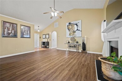 Living room featuring arched walkways, a fireplace