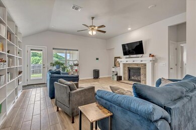 Living room with light wood-style floors, a ceiling fan, a brick fireplace, lofted ceiling, and recessed lighting