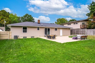 Rear view of house with a patio, a lawn, and centr