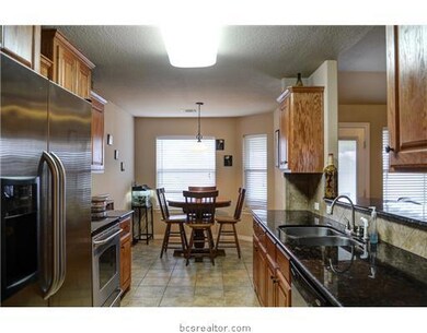 Kitchen. Granite countertops and stained cabinets.