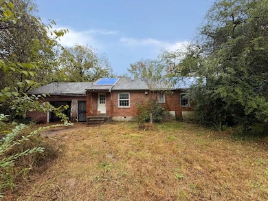 Back of house with a lawn and solar panels