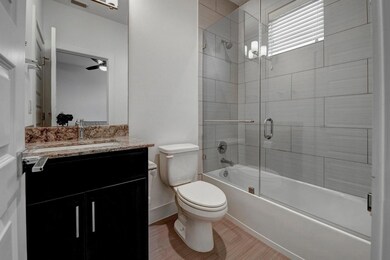 Bathroom with toilet, enclosed tub / shower combo