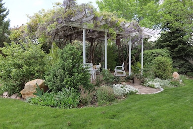 View of green lawn with a patio and a pergola