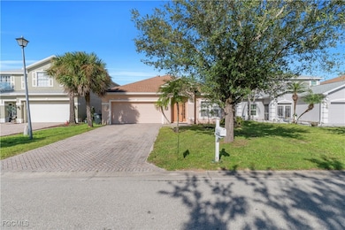 View of front of home featuring decorative driveway, an attached garage, a front lawn, and stucco siding