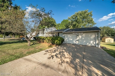 View of front of home featuring a front yard, a garage, and driveway