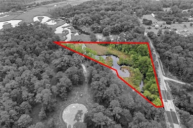 View of property location with a heavily wooded area and property parcel outlined