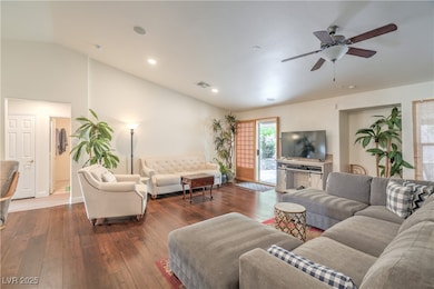 Living area featuring a ceiling fan, hardwood / wood-style floors, vaulted ceiling, and recessed lighting