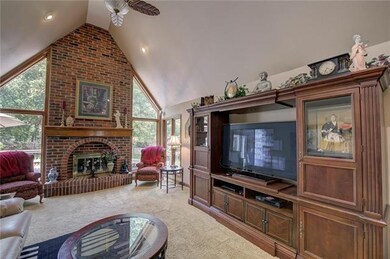 Wall of windows captures the backyard oasis from your living room with vaulted ceiling
