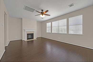 Large living room with lots of natural lighting and a fireplace.