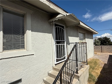 Entrance to property with stucco siding and fence