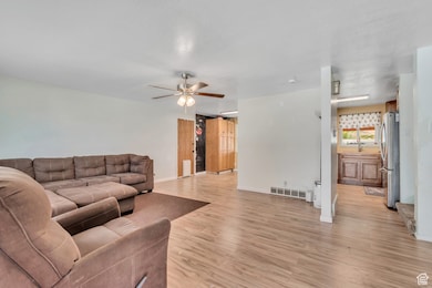 Living area featuring light wood finished floors and a ceiling fan