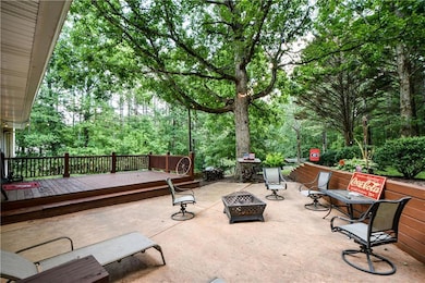 View of patio with an outdoor fire pit and a deck