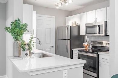 Kitchen with white cabinetry, stainless steel appl