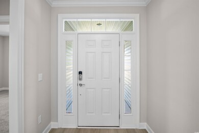 Foyer with ornamental molding and light wood-style floors
