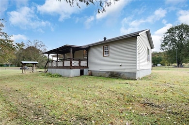 Back of house with a lawn and a wooden deck