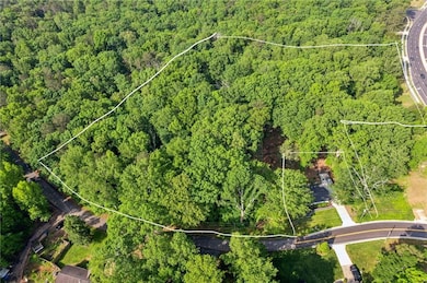 View of property location with a heavily wooded area and property boundaries highlighted