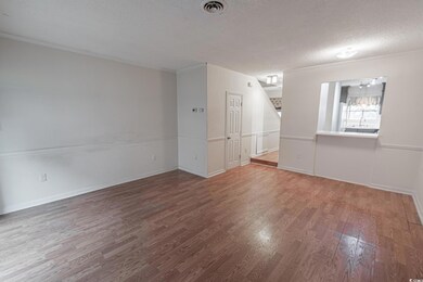 Empty room featuring wood-type flooring, crown mol