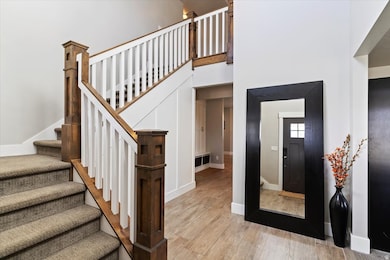 Stairs featuring a high ceiling and wood finished floors