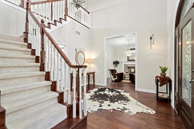 Entryway with stairs, a high ceiling, baseboards,