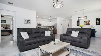 Living room with light tile patterned flooring, a chandelier, and recessed lighting
