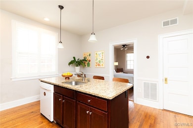 Kitchen featuring a sink, white dishwasher, decora