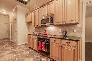 Kitchen features custom wood cabinets, microwave, oven, pantry, granite counter tops, under the cabinets lighting.