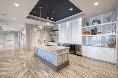 Kitchen with decorative light fixtures, white cabi