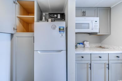 Kitchen featuring gray cabinets, open shelves, and white appliances