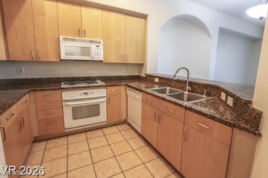Kitchen with white appliances, dark stone countert