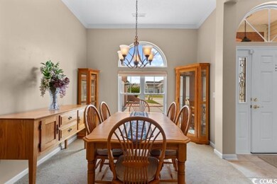 Dining room featuring light carpet, crown molding,