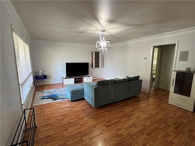 Living area featuring wood finished floors, crown 