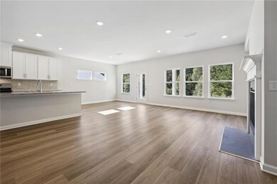 Unfurnished living room featuring wood finished floors, recessed lighting, and a fireplace with flush hearth