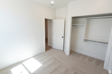 Unfurnished bedroom featuring light colored carpet and a closet